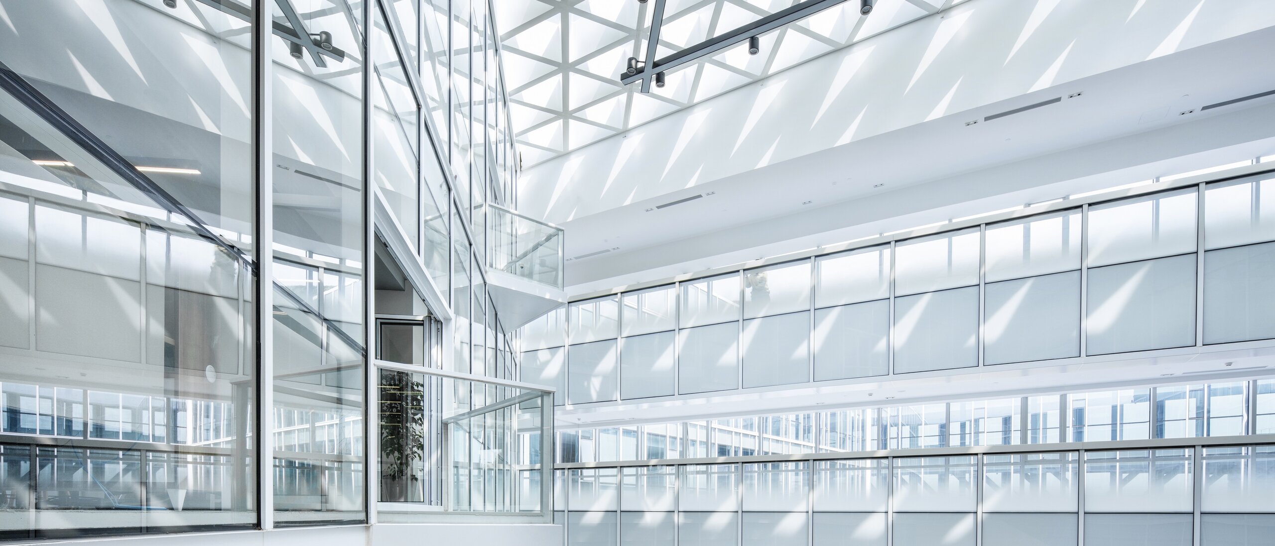 Interior shot of a multi-storey building corridor with bright daylight, balconies and railings