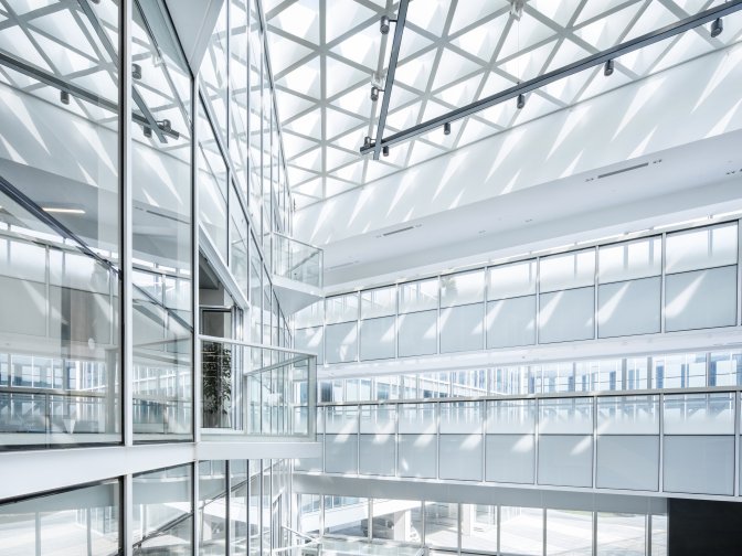 Interior shot of a multi-storey building corridor with bright daylight, balconies and railings